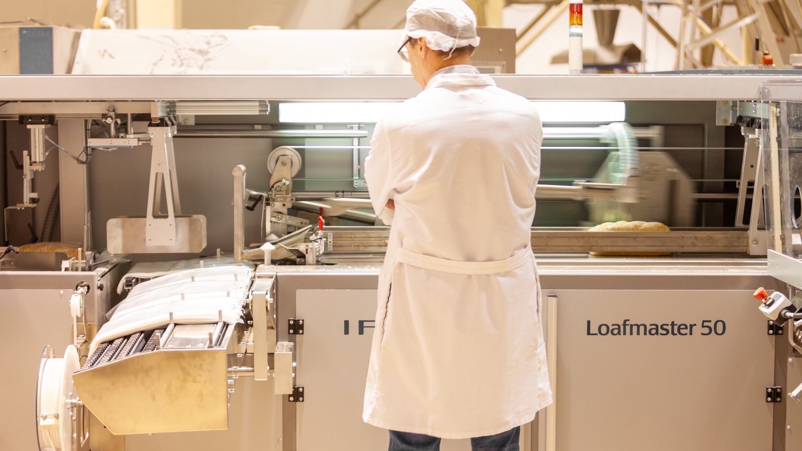 Bakery manager observing automatic sliced bread bagging by Ipeka Loafmaster